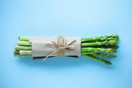 bunch of fresh green asparagus on a blue background.