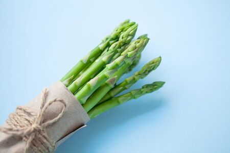 bunch of fresh green asparagus on a blue background.の写真素材