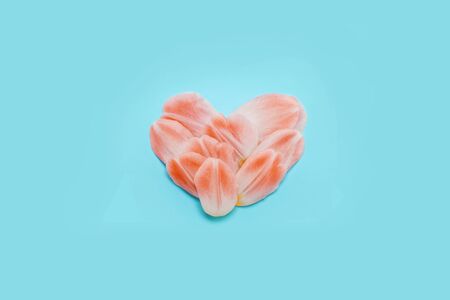 spring concept heart of tulip petals on a blue background. place for your text.