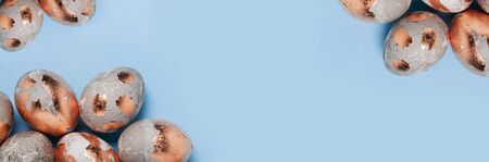 Easter minimalistic concept. Golden eggs on a blue background, banner format