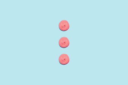 Three spots of pink paint on a blue background. Cream, cosmetic, topping for your design.の写真素材