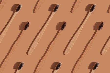 A row of wooden toothbrushes on a brown background.の写真素材