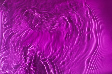 Abstract violet background of waves and ripples on the water.の写真素材