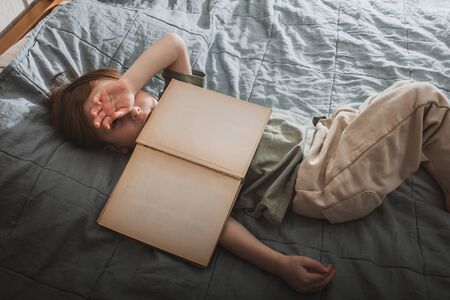A little boy wakes up after a boring book. Mock Up Book Page.の写真素材
