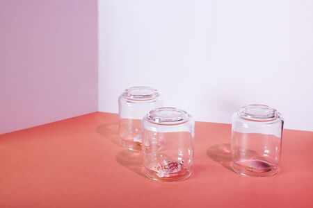 Quarantine summer vacation concept. Three shell under a glass cap on a geometric two-tone backgroundの写真素材