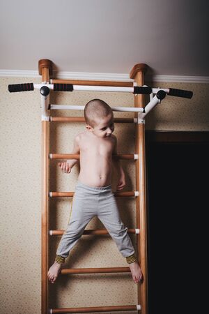 Home workout. The boy climbed the climbing wall.の写真素材