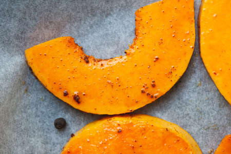 Close up semicircle bright slice of pumpkin prepared for baking in the oven.の写真素材