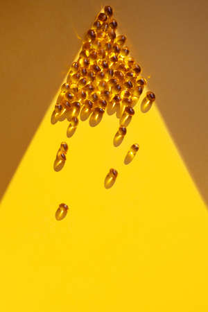 Vitamin D concept in the sunlight. Vitamin gelatin capsules in a ray of lightの写真素材