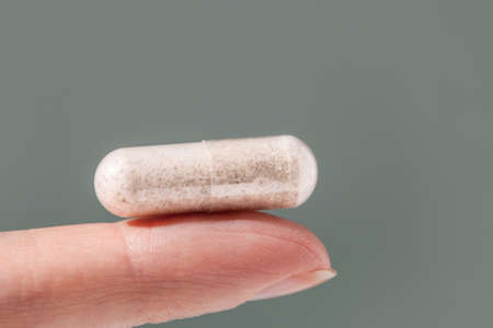 Female hand holding a capsule of food supplement. Food supplement, multivitamins, medicines, dietary...