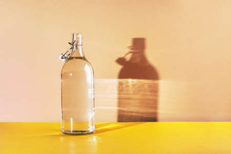 Glass bottle with clean drinking water lit by the sun. background with place for textの写真素材
