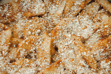 Close up of raw apple pie. Apple wedges sprinkled with nut crumbs