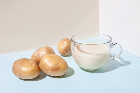Potato milk. A cup with milk and potato tubers side view. Alternative plant milkの写真素材