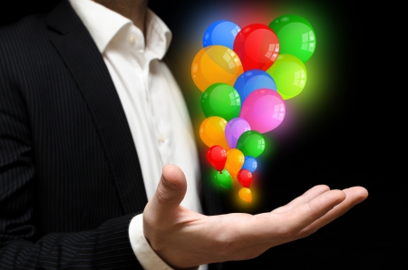 Man releasing colorful balloonsの写真素材