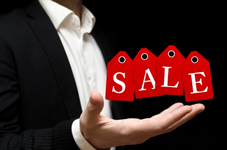 Man holding sale red labels on black backgroundの写真素材