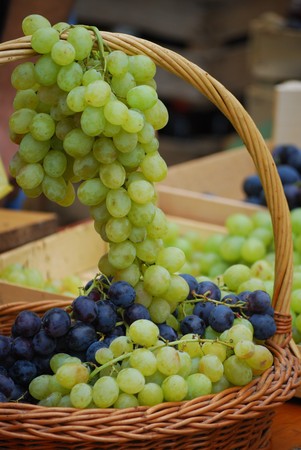 close up of the white and the dark wine grapes in basketの写真素材