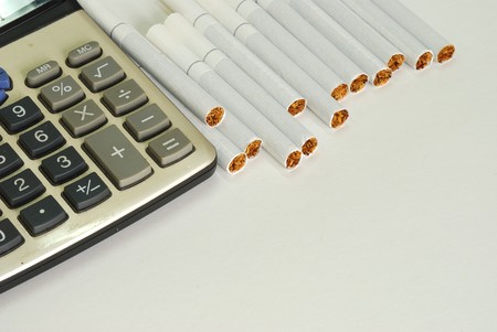 close up of the calculator and the cigarette on white backgroundの写真素材