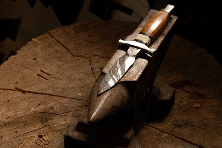 hand made damascus knife on anvil in smithy