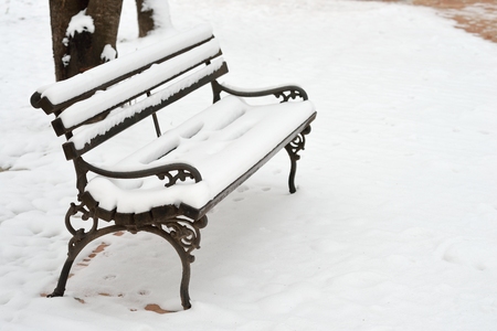 Bench in Park covered with Snow on a Cold Winter Dayの写真素材