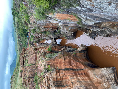 Majestic red rock canyon of Bourke's Luck Potholes with muddy river stream and walkways in Mpumalanga, South Africa â geological landmark and nature attractionの写真素材