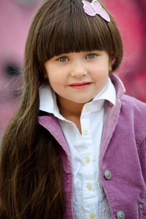 portrait of little girl outdoors in a pink jacketの写真素材