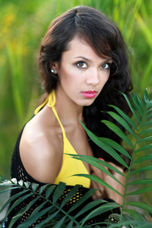 beautiful elegant brunette girl with palm treeの写真素材