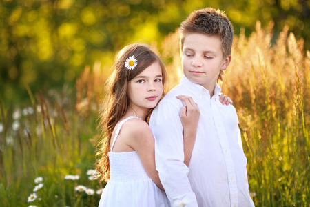 Portrait of a boy girl in a summer with daisiesの写真素材