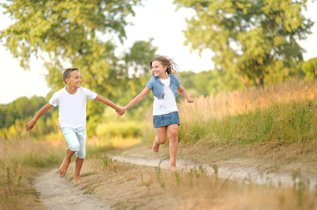 Portrait of a boy and girl on the field in summerの写真素材