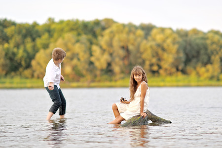 Portrait of a boy and girl playing on the beachの写真素材