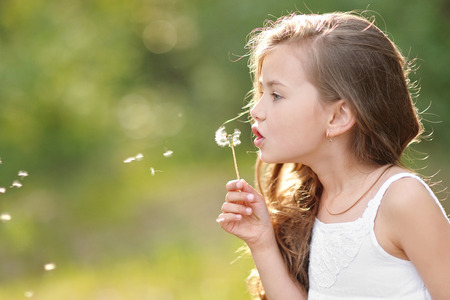 portrait of a beautiful little girl with flowersの写真素材