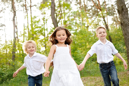 three children playing on meadow in summerの写真素材