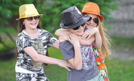 three children playing on meadow in summerの写真素材
