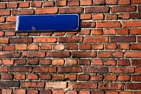 brick wall with an empty streetsignの写真素材