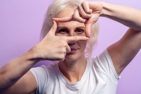 Beautiful young woman makes finger frame gesture