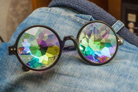 designer glasses with kaleidoscope glasses on jeansの写真素材