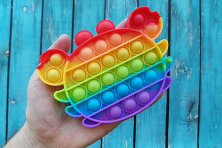 very popular  toy for adults and children, antistress on blue wooden backgroundの写真素材