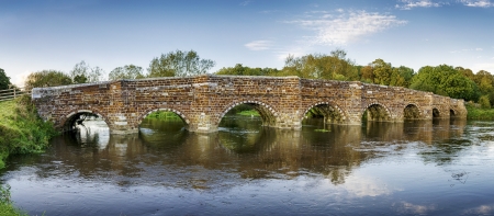An historic ironstone bridge over the River Stour at Sturminster Marshall, near Wimborne Minster and reputedly the oldest bridge in Dorset.の写真素材