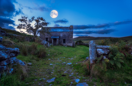 Creepy derelict haunted house under a full moon の写真素材