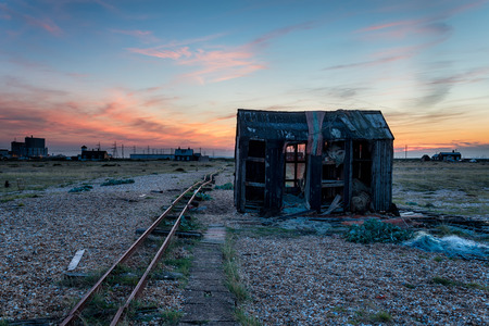 An old abandoned fishing hut on a pebble beachの写真素材