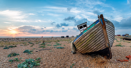 Beautiful Sunrise over Boats on a Pebble Beachの写真素材