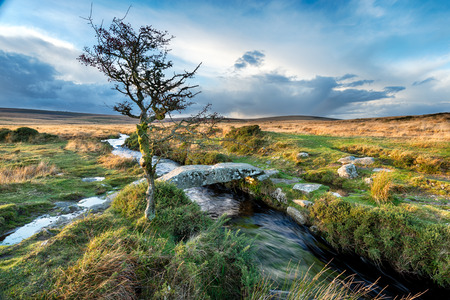 A small granite clapper bridge crossing Gallaven Brook at Scorhill on Dartmoor National Park in Devonの写真素材
