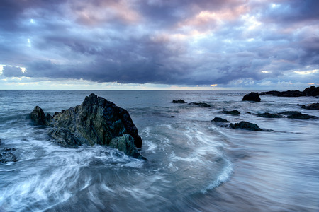 The tide flowing over rocks on the beach at Portwrinkle on the south coast of Cornwall