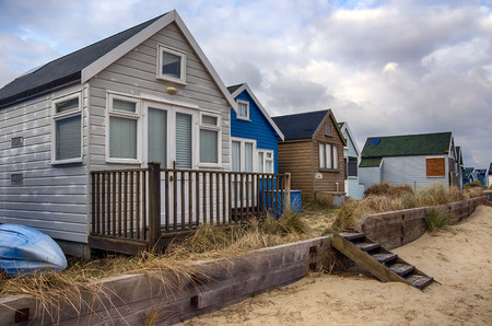 Beach huts under a cloudy sky on Mudeford Spit at Hengistbury Head near Christchurch in Dorsetのeditorial素材