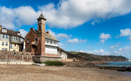 The clock tower and beach at low tide at Kingsand on the Rame peninsula in south east Cornwall