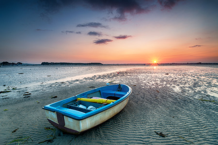 A boat at sunset on the beach at Sandbanks in Poole, Dorsetの写真素材