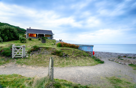 Dusk over a house on the beach at Millook Haven near Bude on the Cornish coastのeditorial素材
