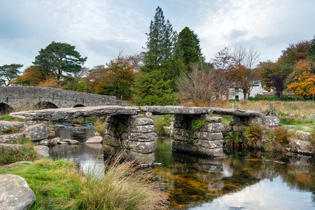 An ancient granite clapper bridge crossing the East Dart river at Postbridge on Dartmoor in Devonの写真素材