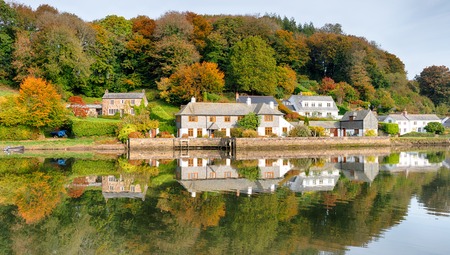 Autumn reflections of a row of cottages on the river Lerryn in Cornwallの写真素材