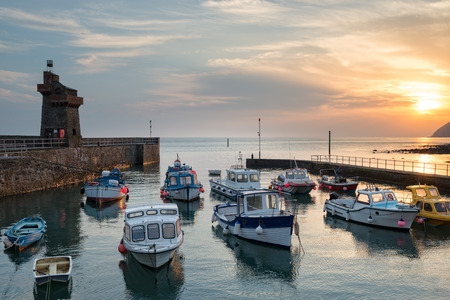 Stunning sunrise over fishing boats in the harbour at Lymouth on the north coast of Devonの写真素材