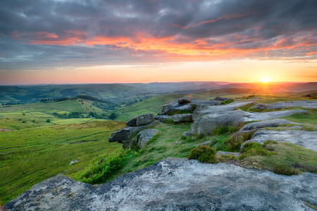 Dramatic sunset sky over Higger Tor in the Peak District national parkの写真素材