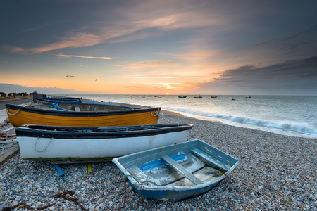 Sunrise over boats on the beach at Selsey on the West Sussex coastlineの写真素材